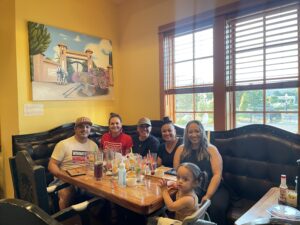 5 adults and a child sitting down at a dinner table.