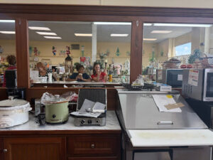 Two women in a mirror at a general store